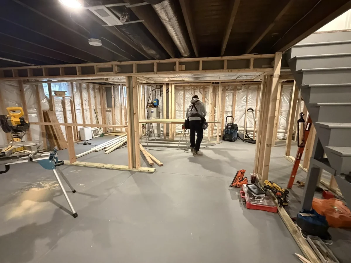 During: new timber stud walls framed out across the basement floor, tools and offcuts still on site.