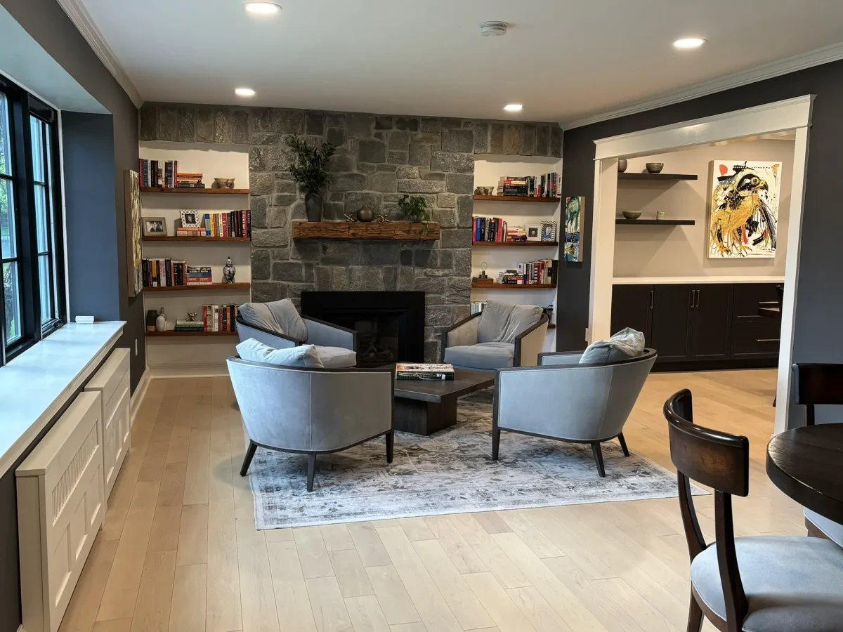 Family room with a floor-to-ceiling stone fireplace, reclaimed timber mantel and built-in shelving on either side.